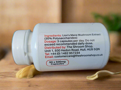 White supplement bottle with black text ingredients on a wooden surface